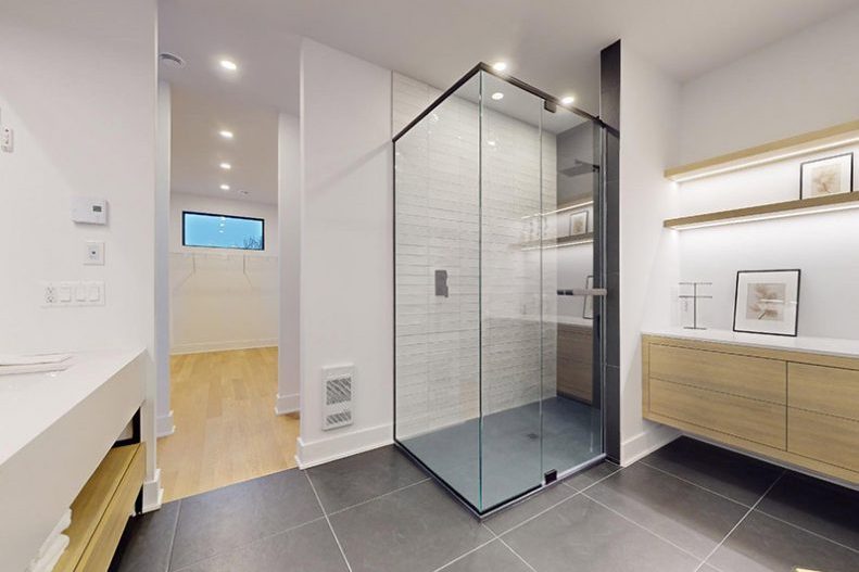 La douche vitrée de la salle de bain principale, vanité de bois et tablettes