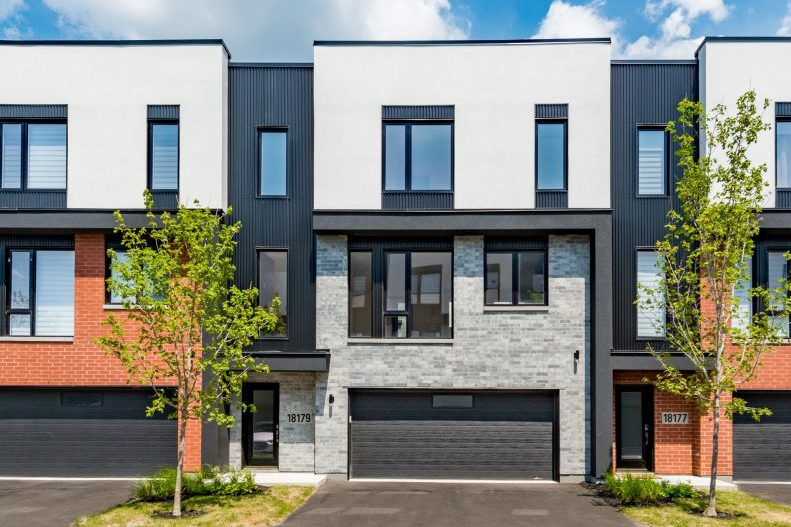 Maisons de ville en rangée des Villas Cité Mirabel : façades blanches, noires et rouille, garages, arbres devant